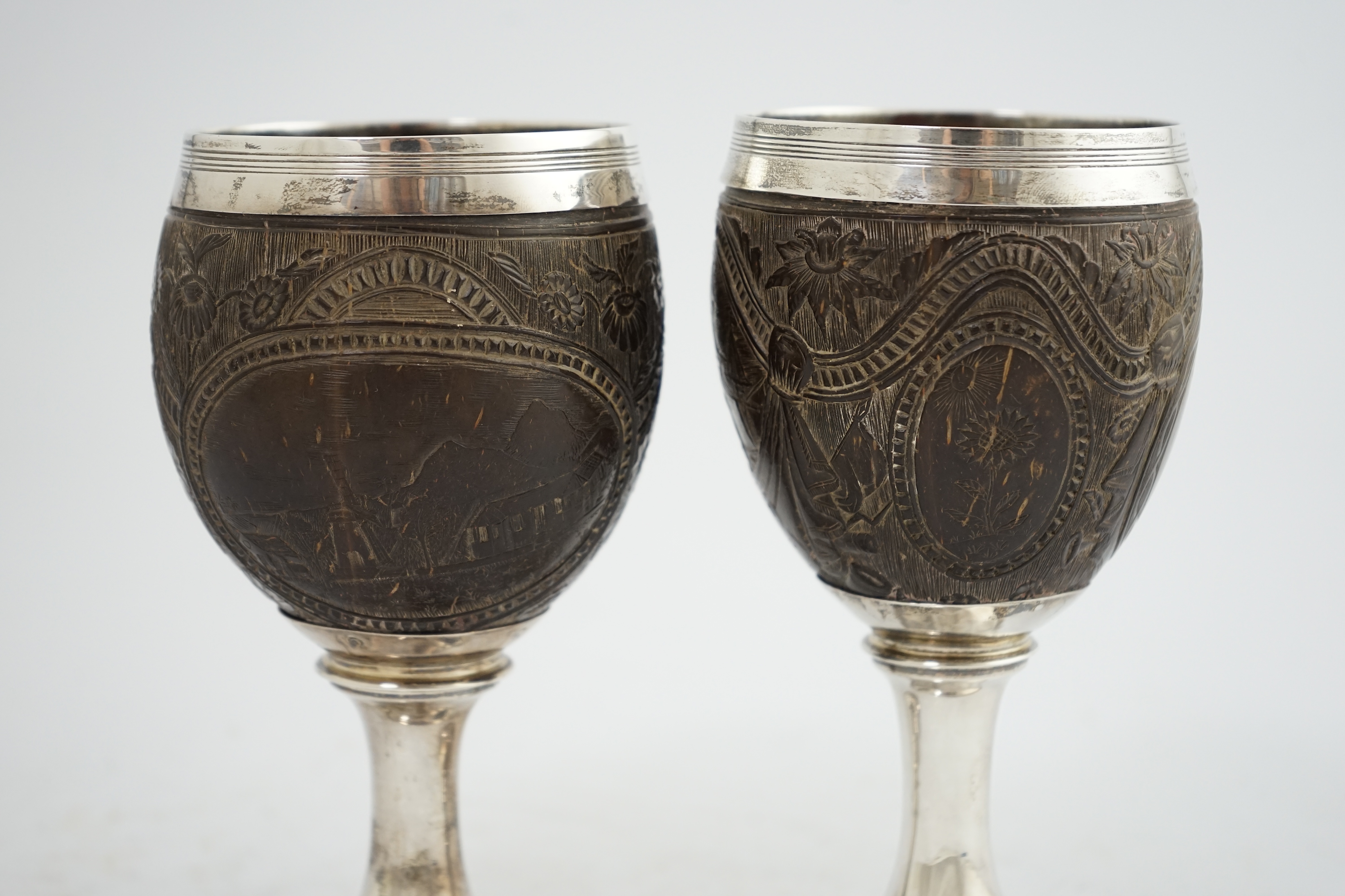 A pair of George III silver mounted coconut cups, maker I.T?